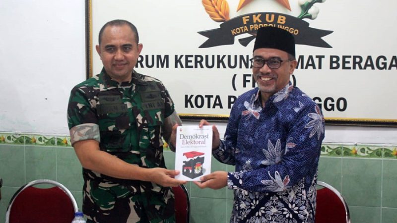 Ketua FKUB Ahmad Hudri menyerahkan kenang-kenangan sebuah buku ke Letkol Arh Iwan Hermaya. Foto: suarabhinneka.id
